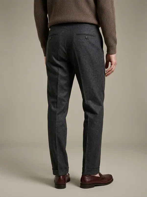 charcoal flannel double-pleat side-tab trousers worn by an AI male model, studio shoot