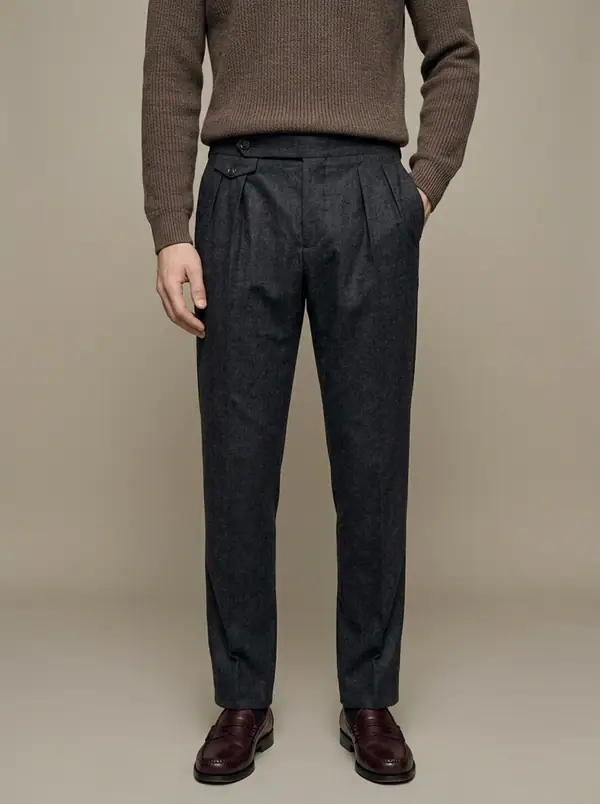charcoal flannel double-pleat side-tab trousers worn by an AI male model, studio shoot