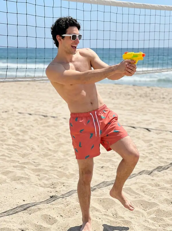 coral printed swim shorts worn by an AI male model, editorial shoot
