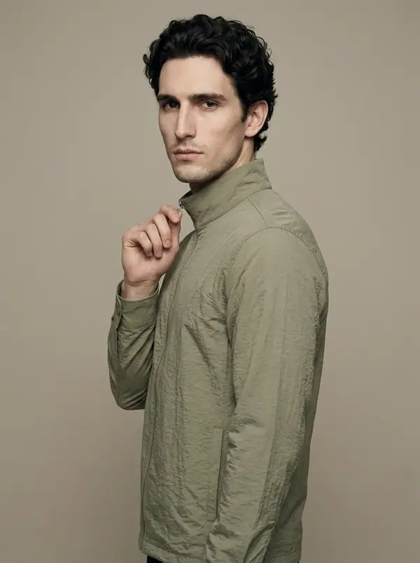 pale sage crinkle-nylon funnel zip overshirt worn by an AI male model, studio shoot