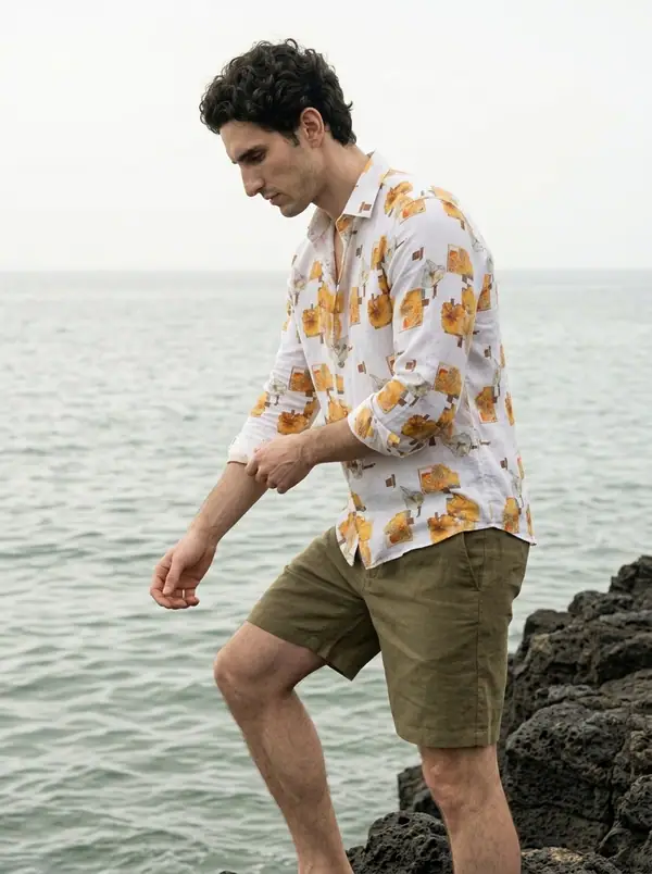 white linen shirt, marigold block print worn by an AI male model, editorial shoot at the sea rocks