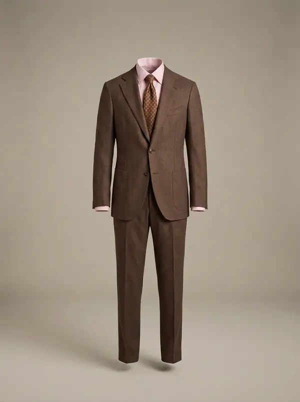 chocolate linen suit + pink shirt + medallion tie, photographed as a product shot on a studio sweep